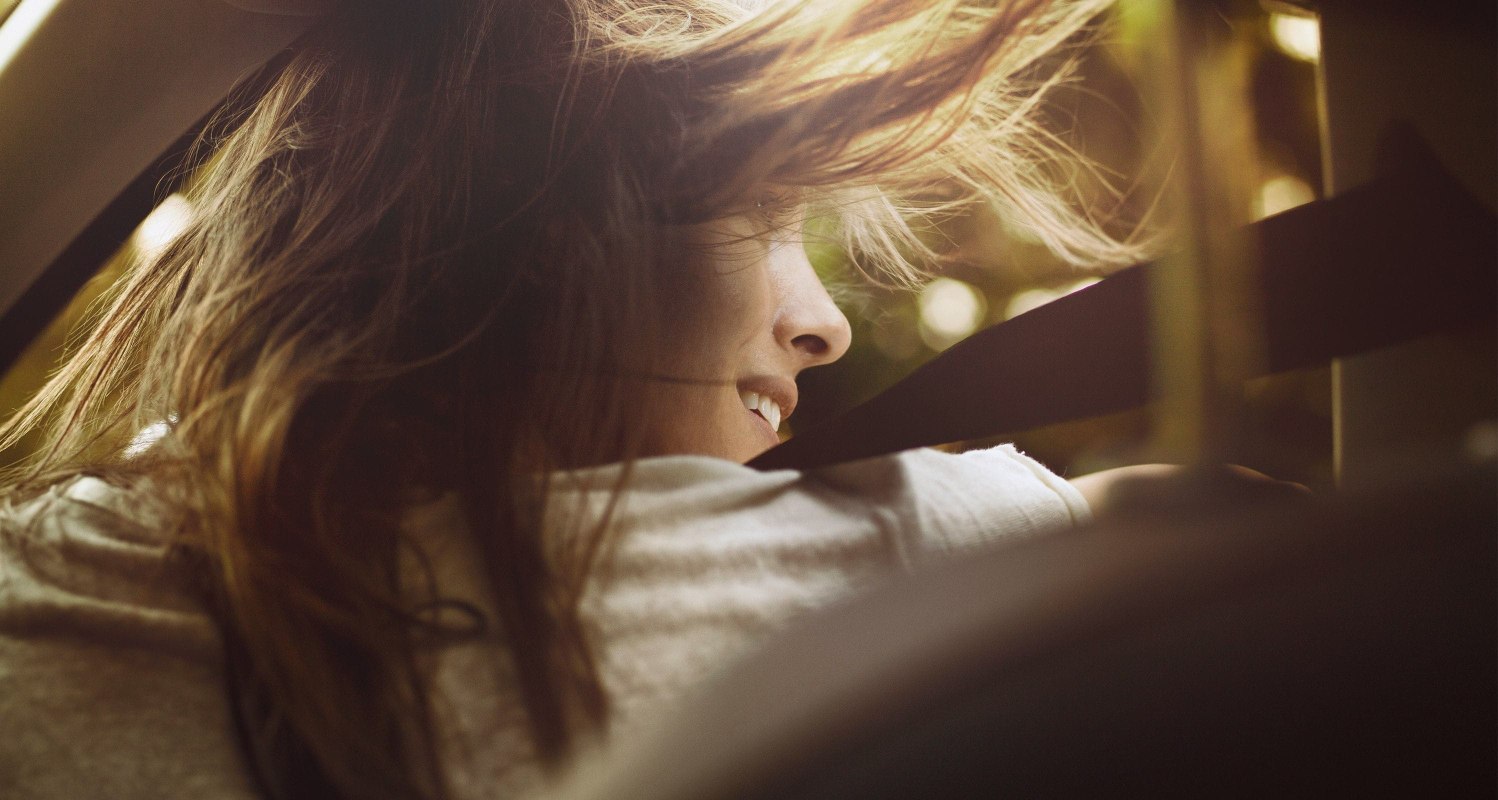 SEAT neuer Service – Weitwinkelaufnahme einer Frau mit wehenden Haaren, die aus einem Wagen aussteigt
