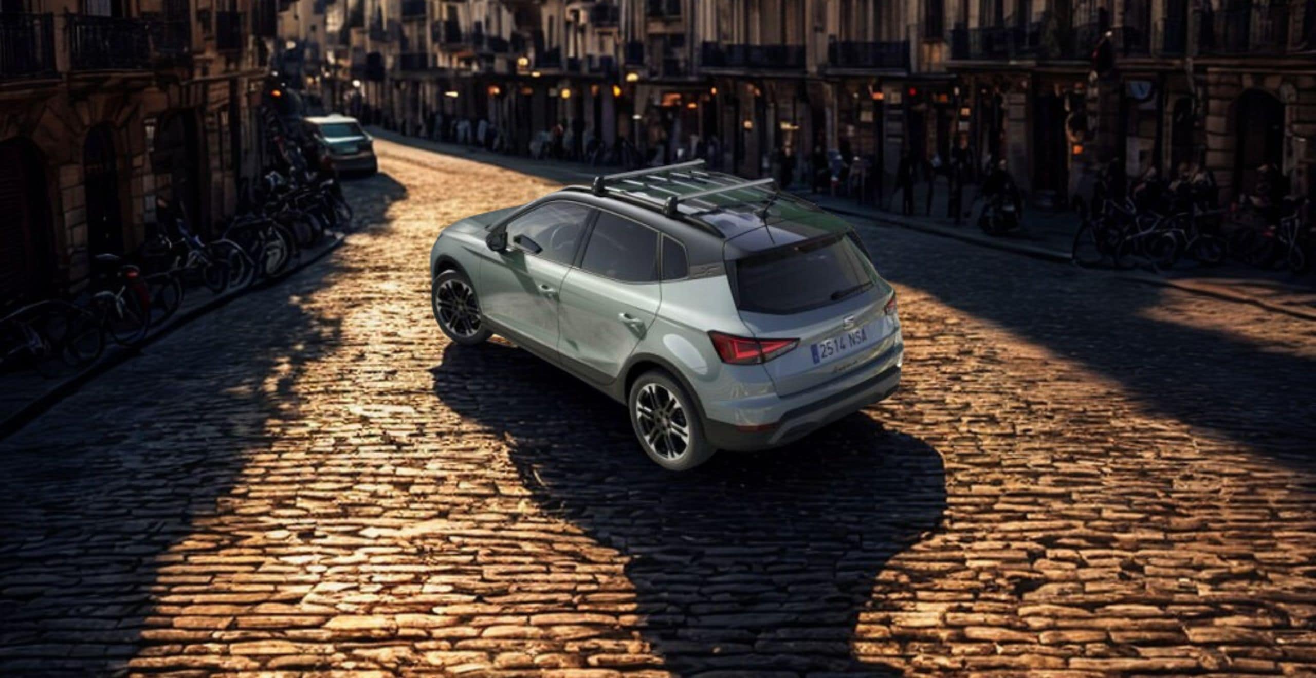SEAT Arona crossover SUV driving in an urban street lined with palm trees