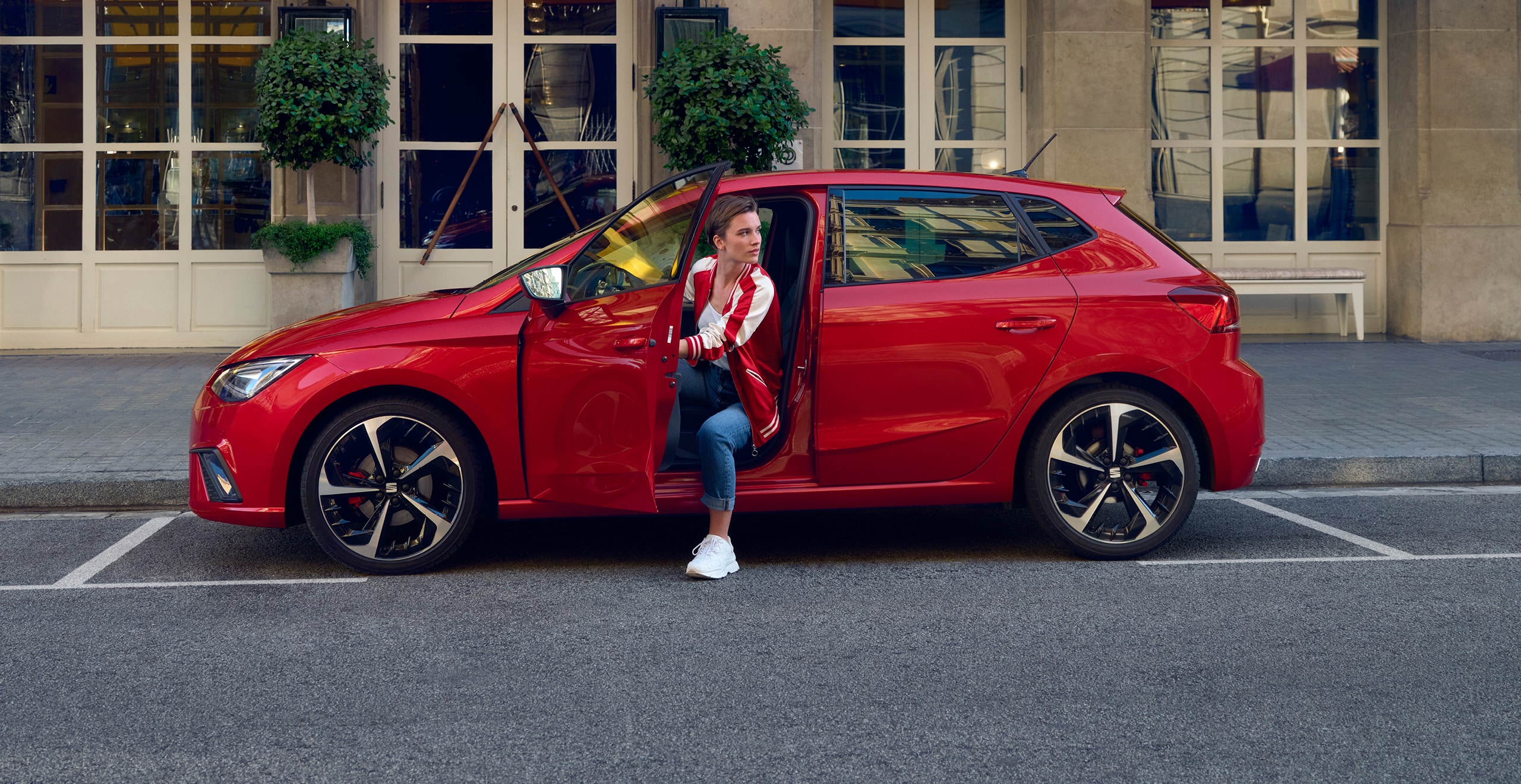 SEAT neuer Service – Frau steigt mit wehenden Haaren aus einem Auto aus