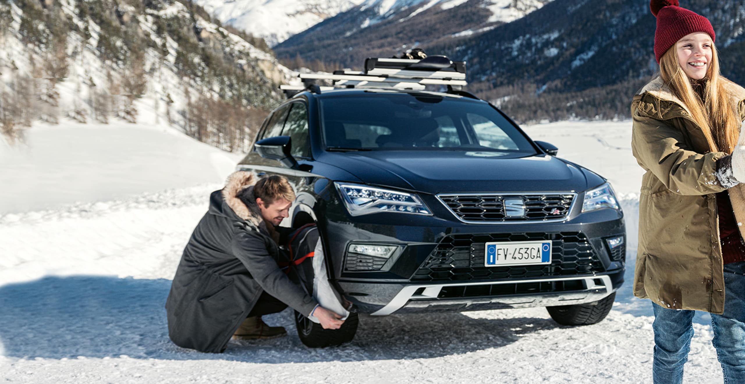 SEAT neuer Service und Wartung – Mann stellt ein Fahrrad auf den Fahrradträger am Heck eines SEAT Arona Crossover