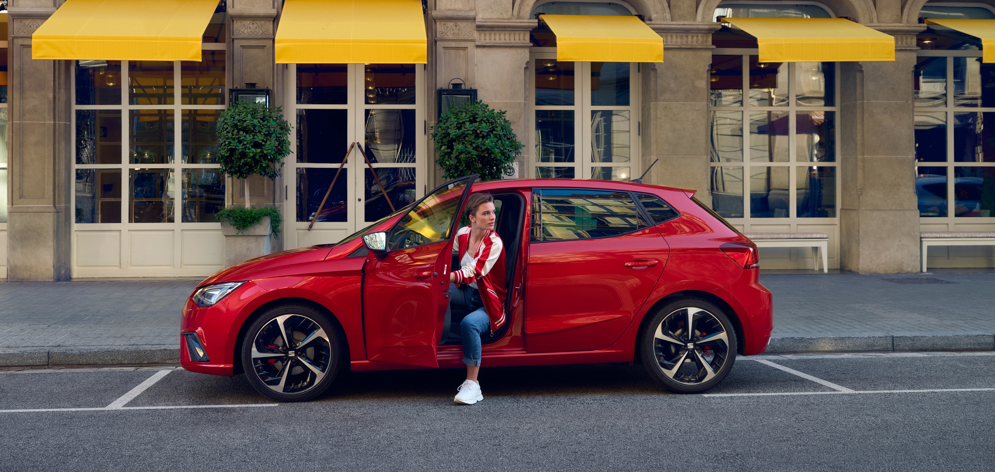 SEAT servizi auto nuove – Panoramica di una donna che esce da un’auto con i capelli al vento