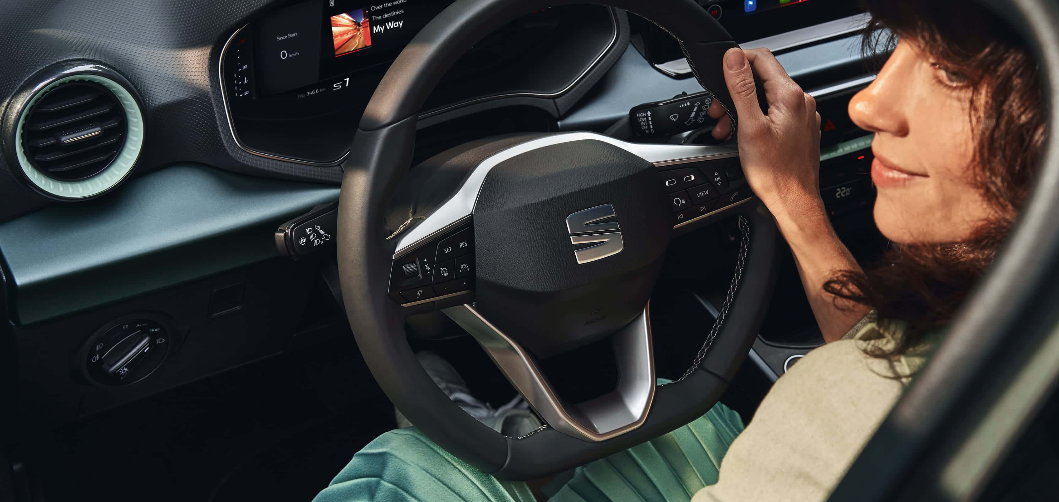 Une femme qui marche en direction d’une SEAT Arona couleur dark camouflage