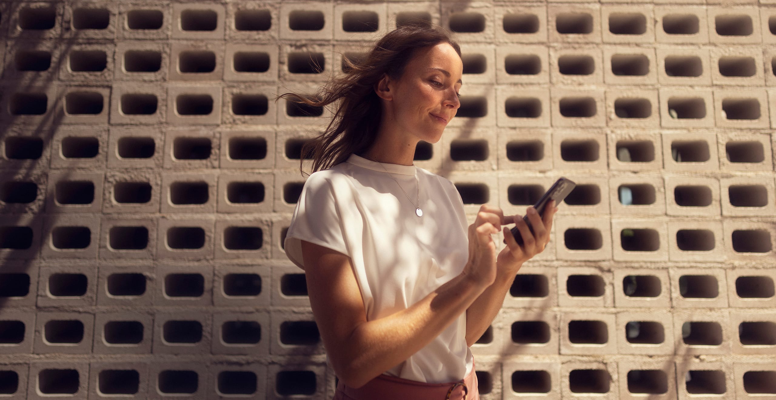 Une femme avec son smartphone connecté à SEAT CONNECT