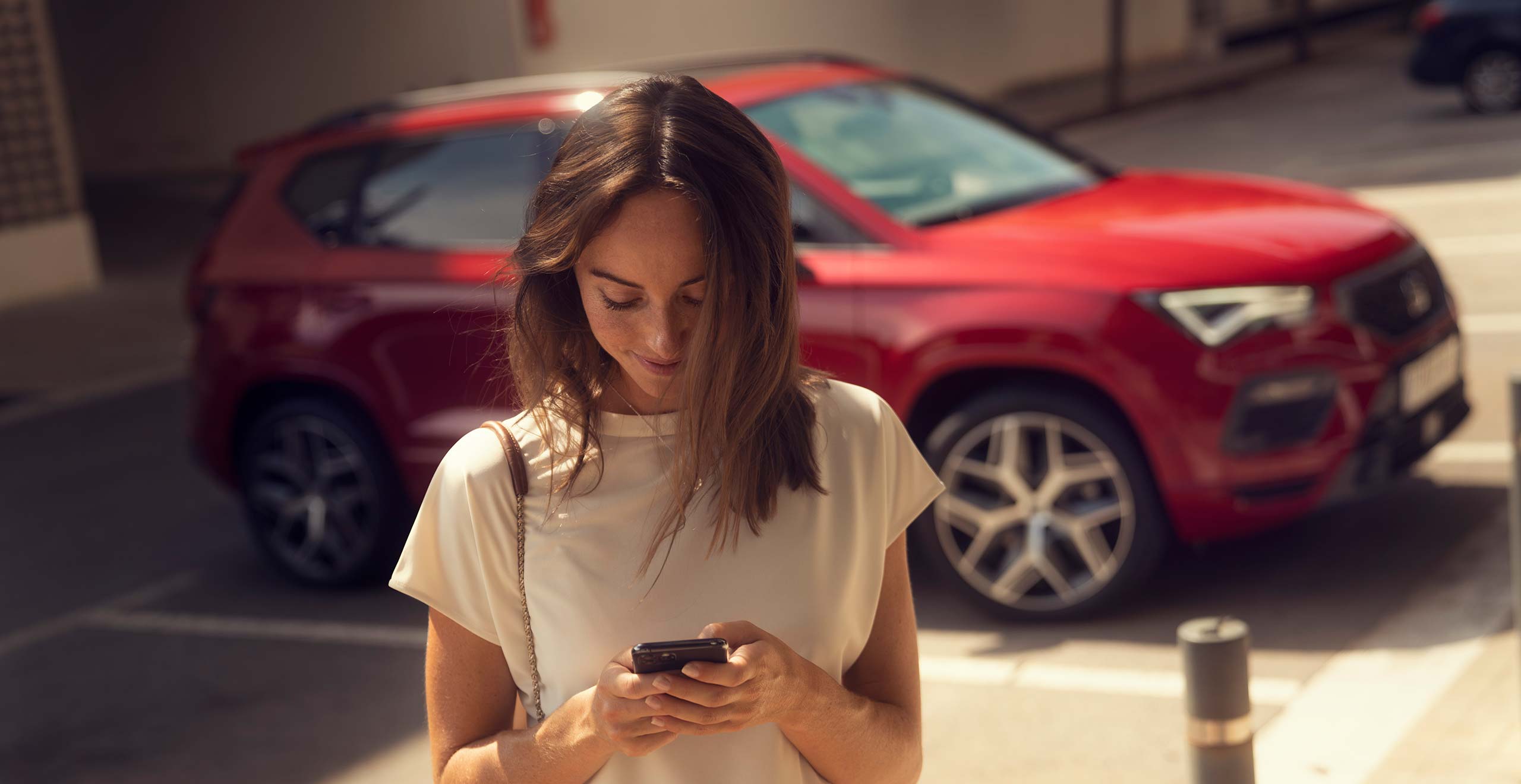 SEAT Fahrzeug-Bring-und-Hol-Service – Wartung und Instandhaltung – Sicht nach draussen aus einem Gemüsegeschäft, man sieht einen SEAT Arona Crossover SUV durch das Fenster