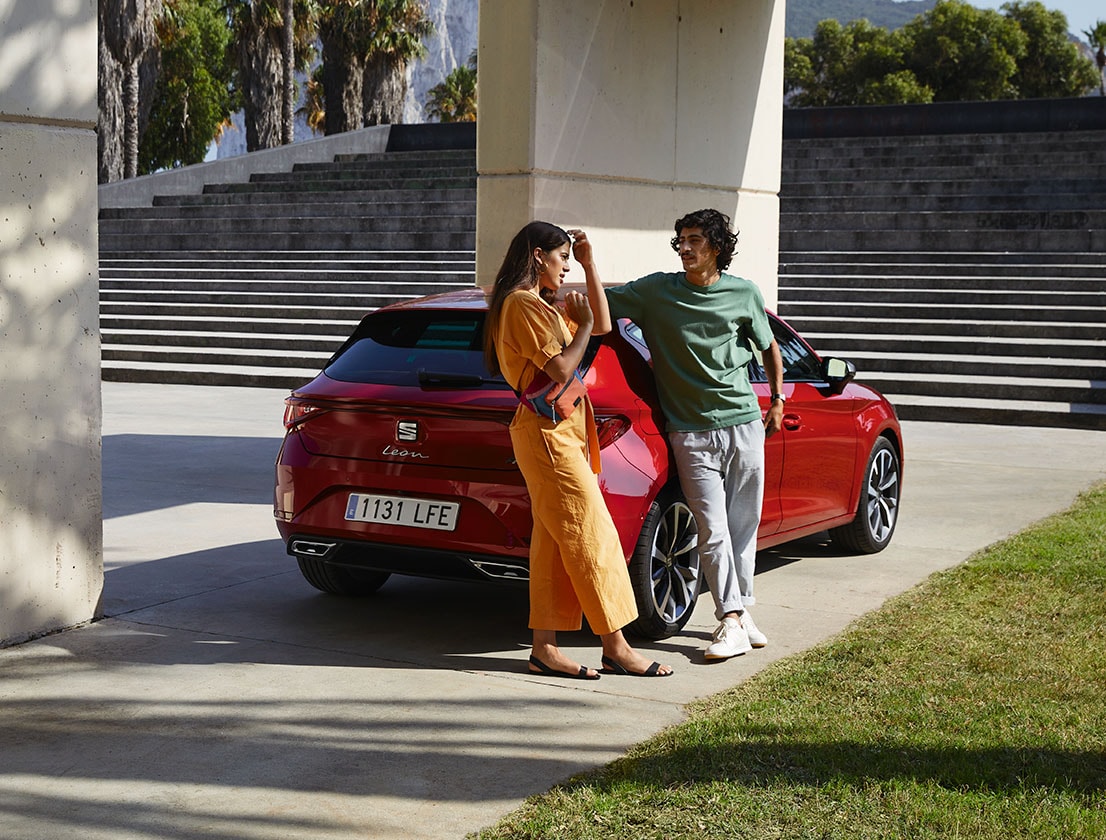 Ein Paar liegt auf dem neuen SEAT Leon in Desire Red 