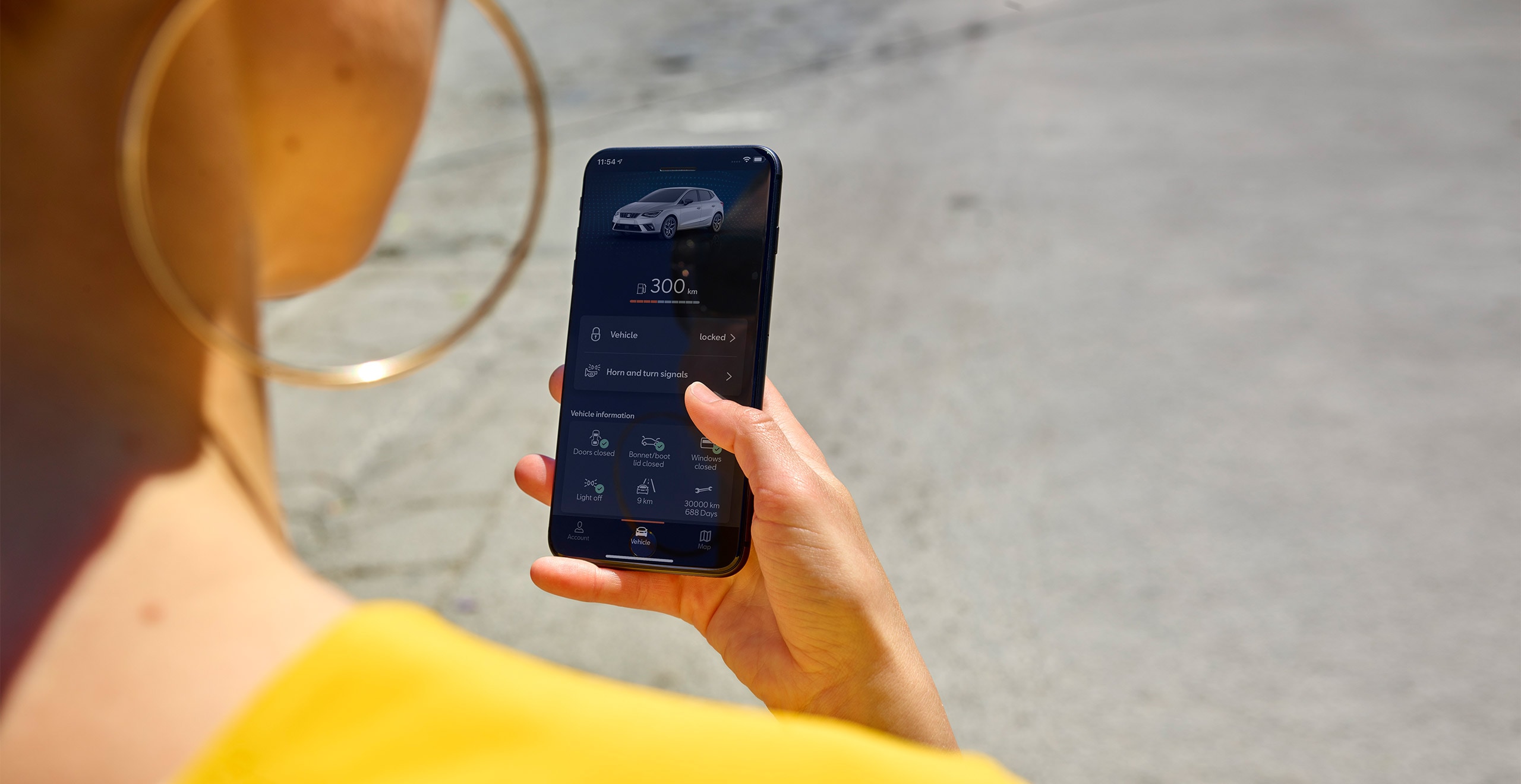 Eine Frau sieht auf ihr Smartphone mit SEAT CONNECT
