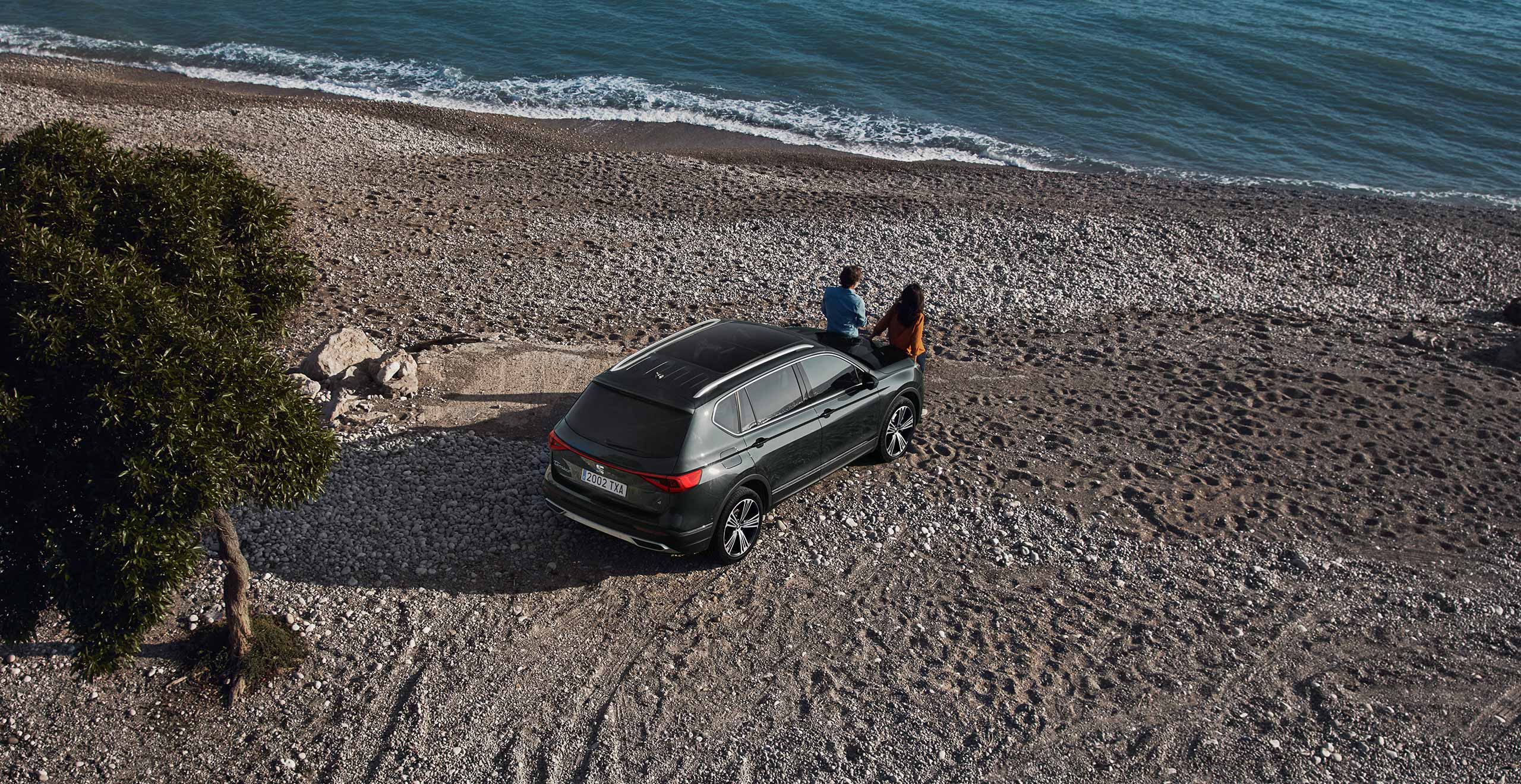 SEAT neuer Service und Wartung – unscharfes Foto von einem Jungen, von Blumen umgeben, mit einer SEAT Toledo Limousine im Hintergrund