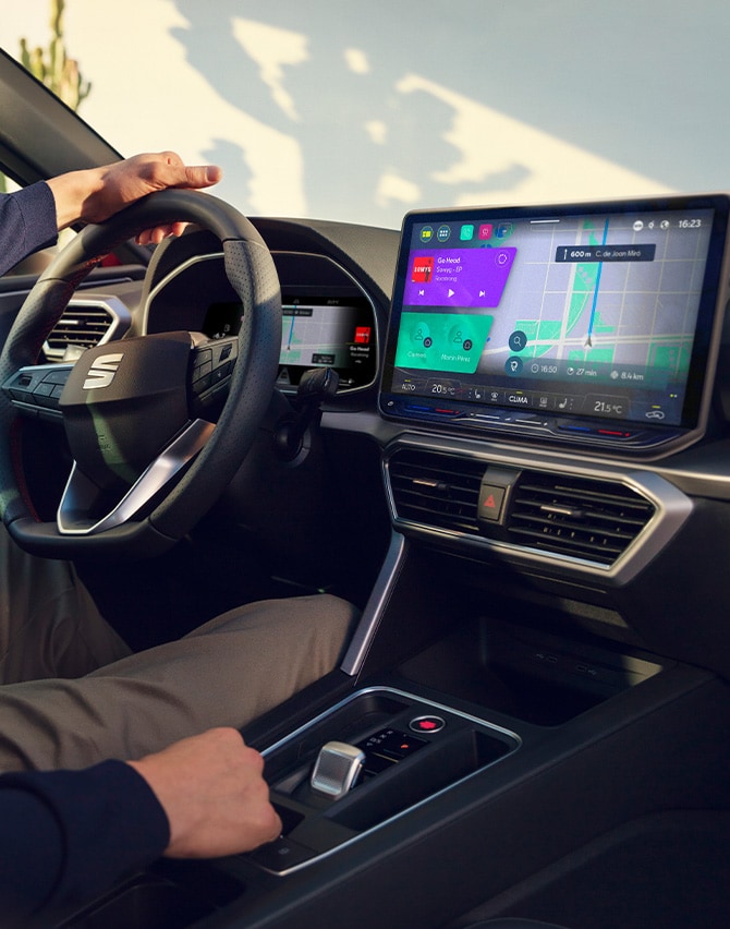 vista interna di un uomo che guida una seat leon e utilizza il cruscotto