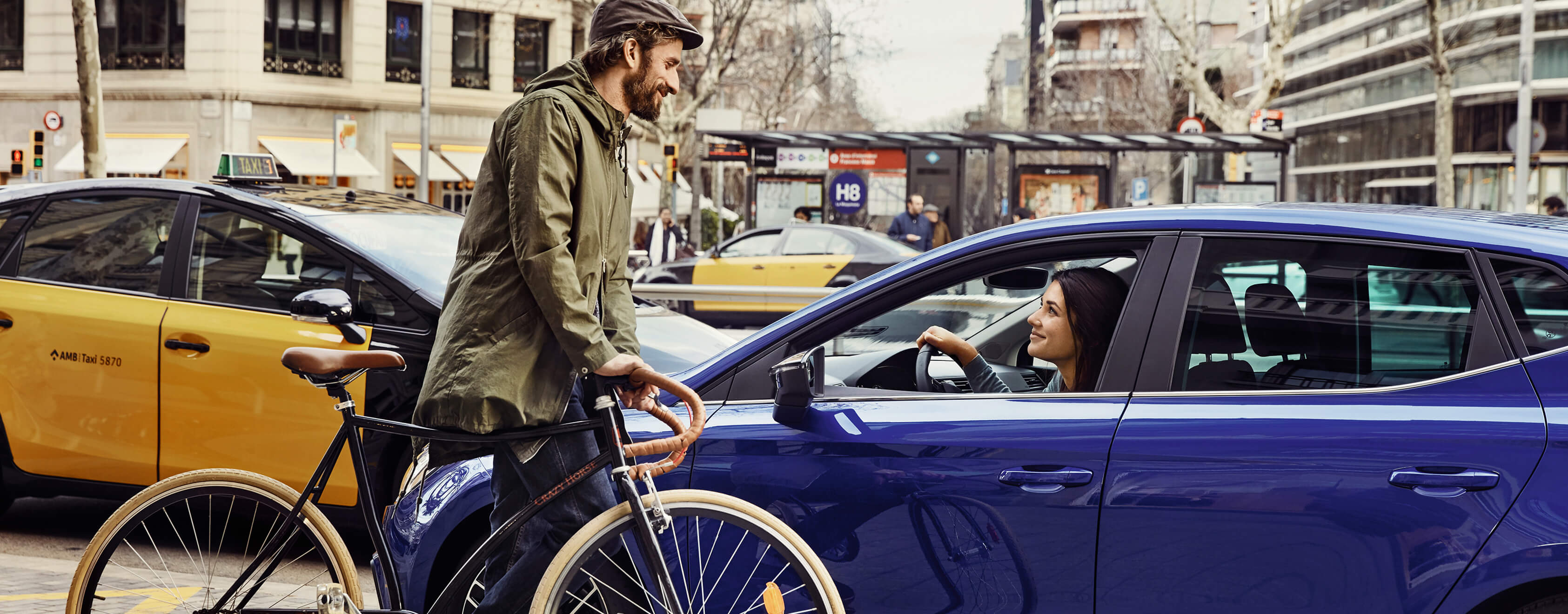 SEAT neuer Service, Wartung und Versicherung – Mann auf Fahrrad vor einem SEAT