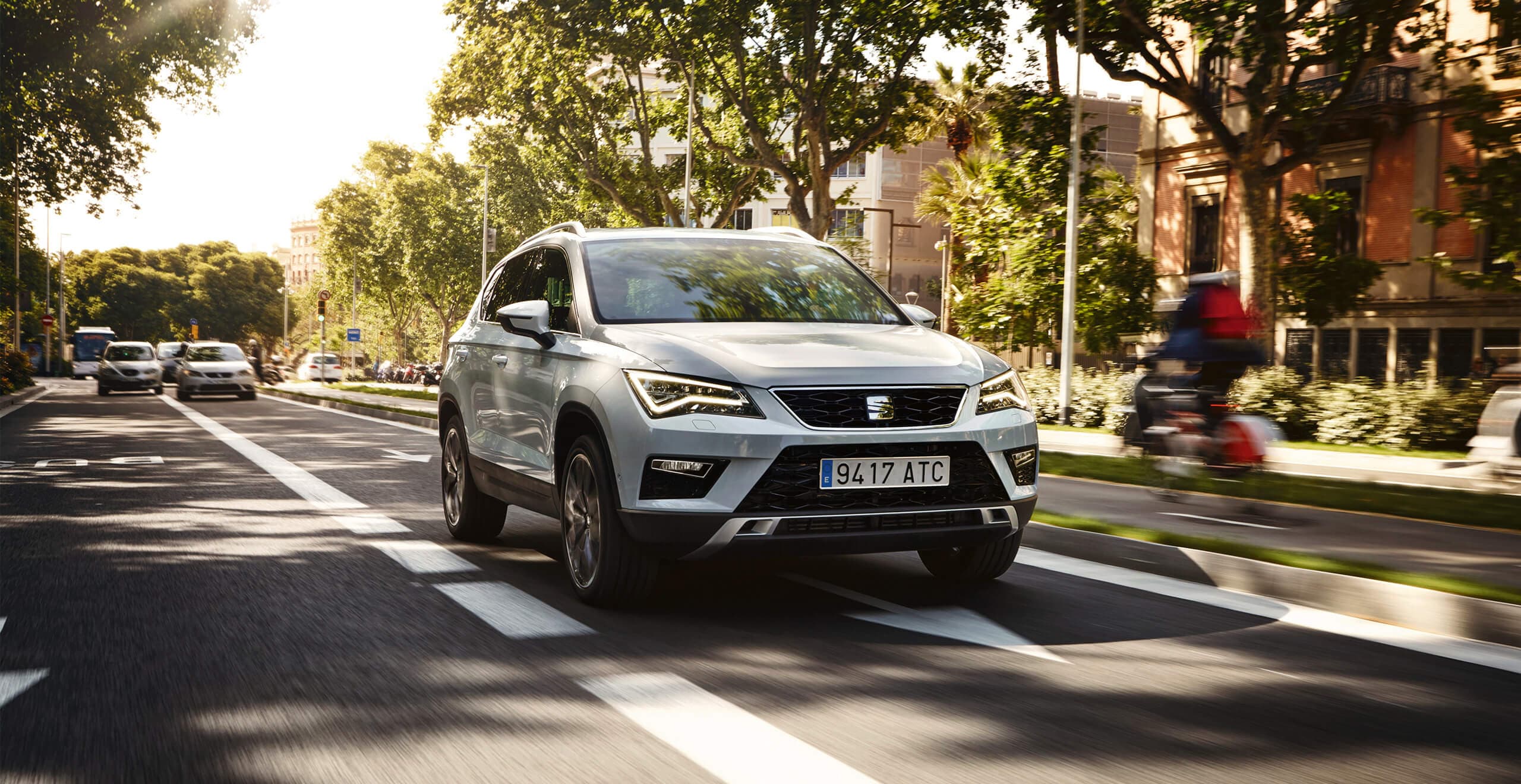 SEAT neuer Service und Wartung – 2 Jahre Garantie – SEAT Ateca SUV fährt auf von Bäumen besäumter Landstrasse